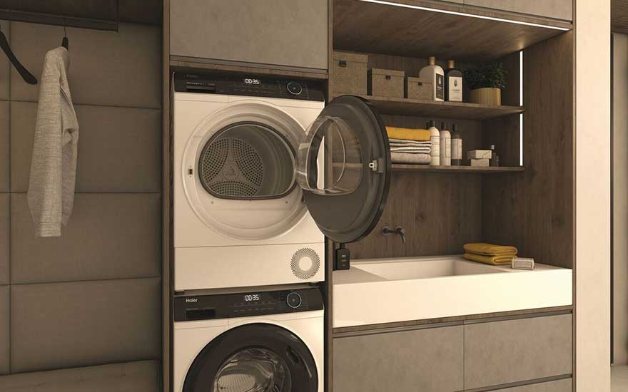 Een stapel wasmachine en droger in een stijlvolle, compacte ruimte met opgevouwen handdoeken, accessoires en een kleine wastafel.