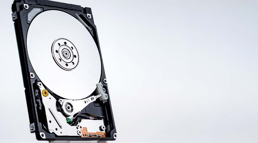 Een interne harde schijf met een zwarte behuizing, een zilveren schijf en interne mechanismen op een witte achtergrond.