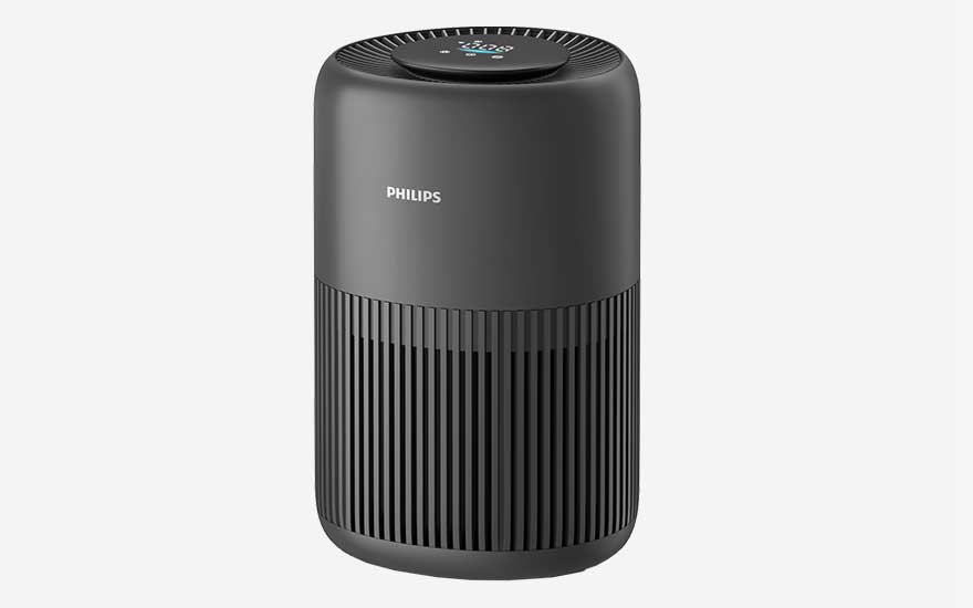 Donkergrijze Philips PureProtect Mini 900 luchtreiniger met afgeronde randen en verticale lamellen, minimalistisch vormgegeven tegen een effen lichte achtergrond.