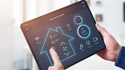 Een tablet toont een smart home-interface met pictogrammen voor temperatuur en beveiliging. Een hand bedient het touchscreen.