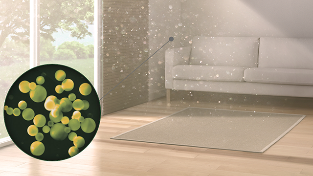 Woonkamer met raam, bank en vloerkleed. Op de voorgrond een cirkel met gele en groene bollen, alsof het bacteriën zijn.