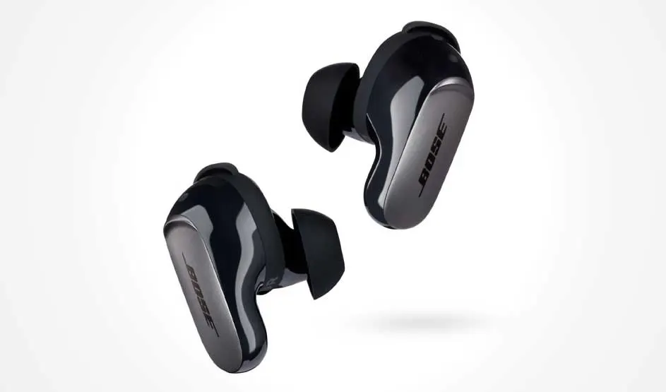 Two black Bose in-ear buds with silicone tips float at an angle; glossy shells with a silver panel on a white background.