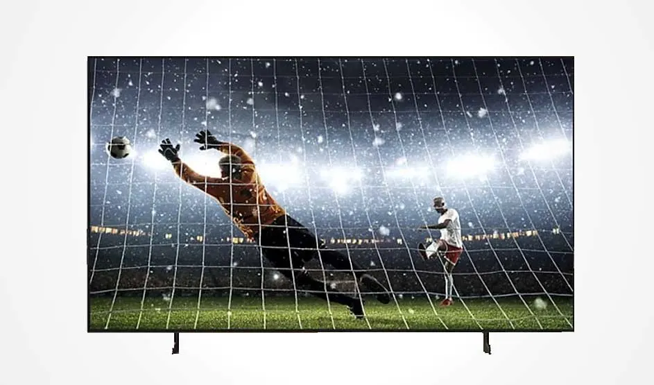 Een grote televisie toont een voetbalscène met doelman die een bal vangt in een stadion met felle lichten. Dynamische actie met groen veld en net. Uitstekende beeldkwaliteit en contrastweergave.