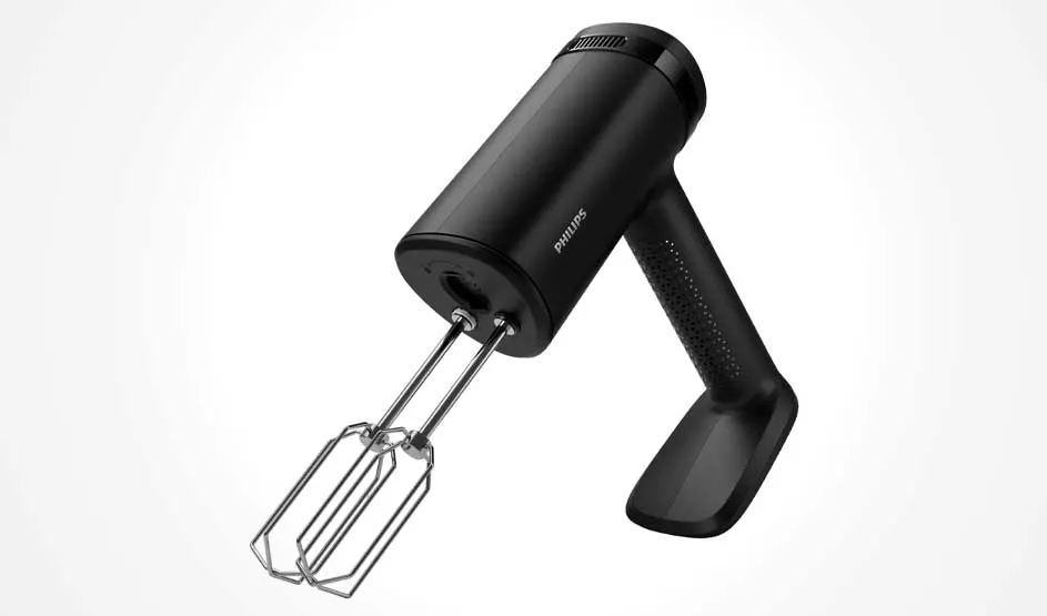 Een zwarte Philips handmixer staat schuin op witte achtergrond; twee metalen gardes steken uit en de greep heeft een textuur voor grip.