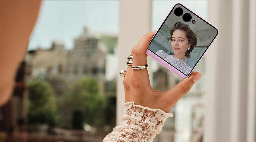 Persoon maakt een selfie met een dichtgeklapte Galaxy Z Flip met cameravoorbeeld op het coverscherm.