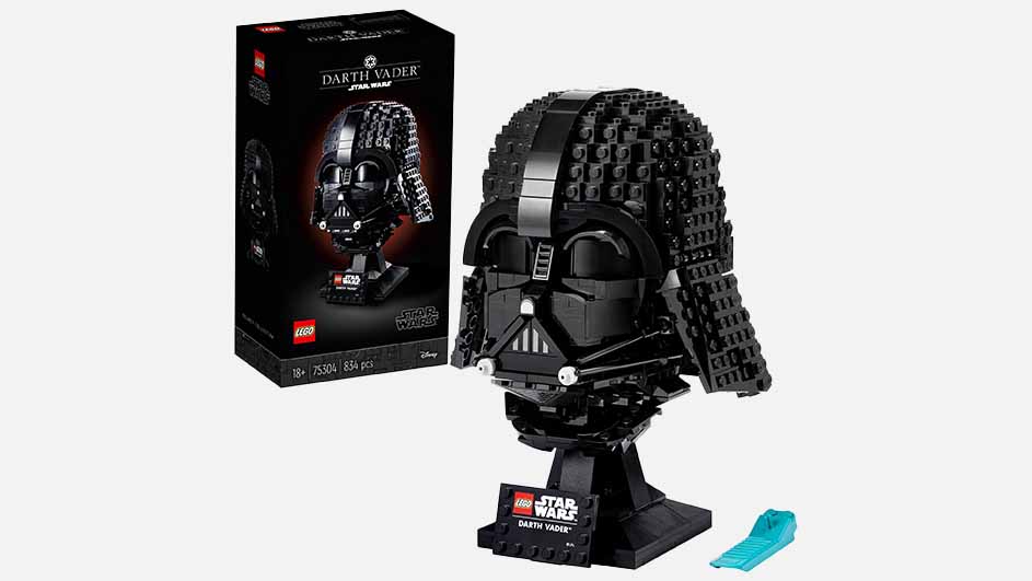 Een zwarte LEGO Darth Vader-helm op een zwarte standaard, met de verpakking op de achtergrond.