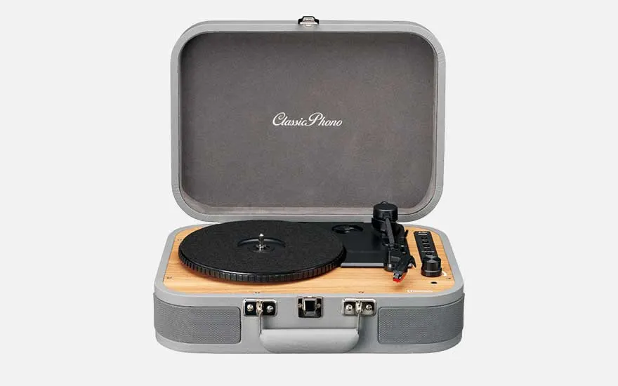 Classic Phono suitcase turntable opened to reveal a wooden deck and black platter, featuring a retro design with metal latches.
