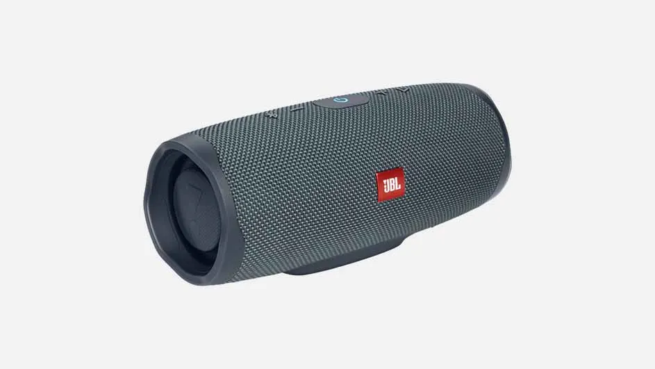 Een grijze JBL Charge-luidspreker ligt diagonaal op een witte achtergrond, met een rood JBL-logo.