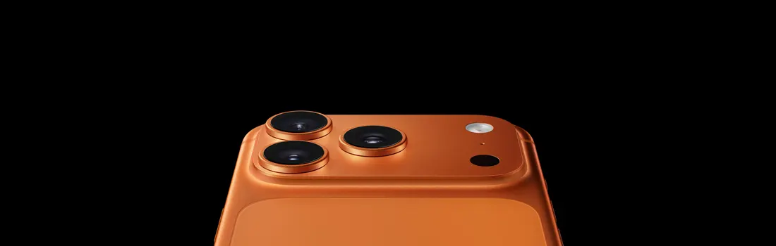 Orange smartphone with three prominent camera lenses and flash emerging cleanly from a black background.