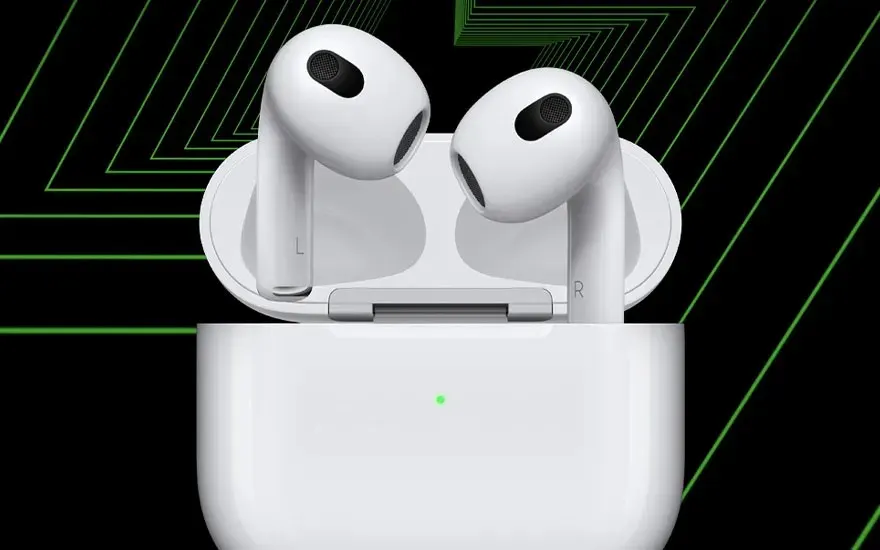 A white pair of wireless earbuds stands upright in an open charging case, set against a bold black and green graphic background.