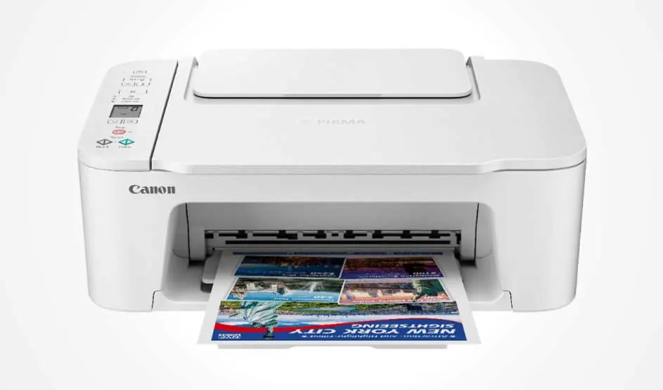 A white Canon printer on a light background, with left-side buttons and a colourful page coming halfway out of the output slot.