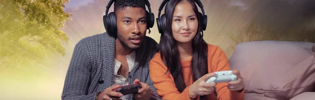 Twee mensen, beiden met koptelefoon op, gamen samen geconcentreerd en plezierig in een gezellige setting met zachte belichting.