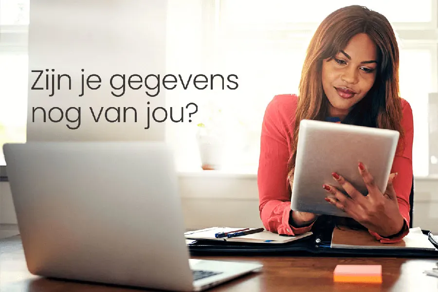 Een vrouw in een rode blouse kijkt naar een tablet, met een laptop aan de linkerkant en de tekst: 'Zijn uw gegevens nog wel van u?'.