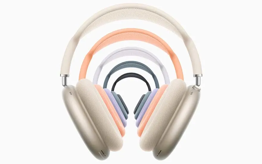Several AirPods Max headphones in soft pastel colours form nested arches, creating a colourful tunnel-like effect on a bright white background.