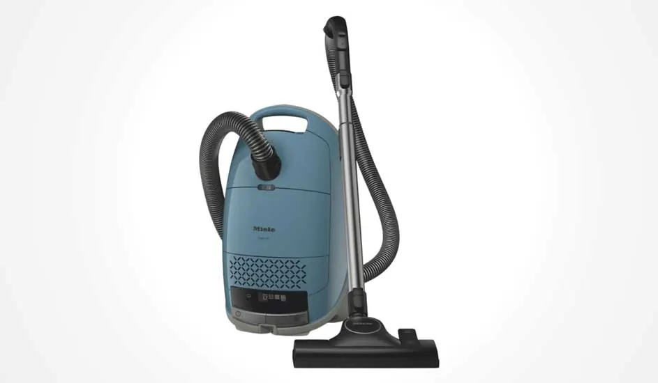 Een blauwe Miele sledestofzuiger staat rechtop, met gebogen slang, zilveren buis en zwarte vloerborstel tegen een witte achtergrond.