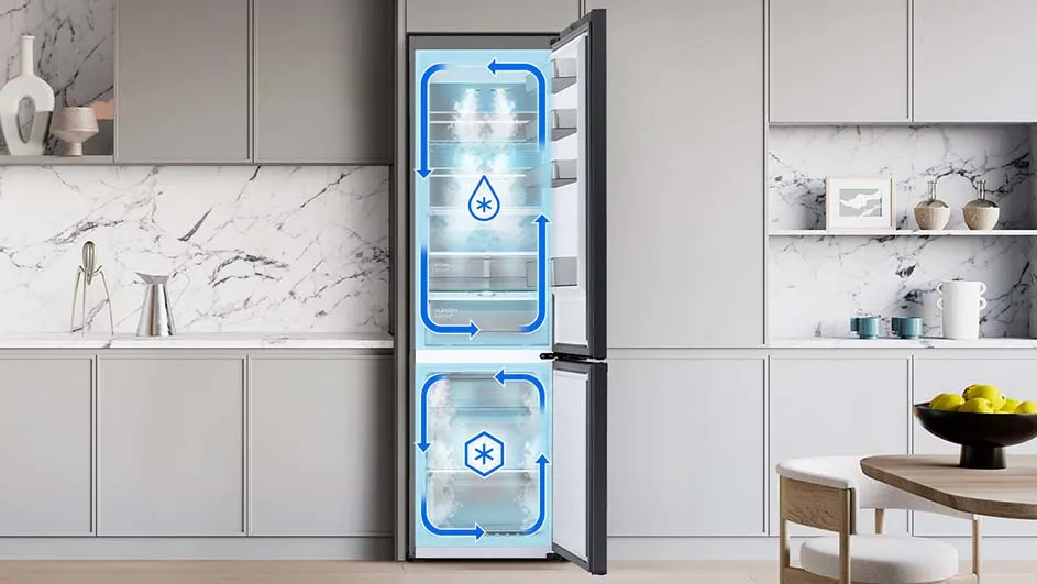 Open koelkast met blauwe pijlen die luchtstroom aangeven, in een keuken met grijze kasten en marmeren achterwand.