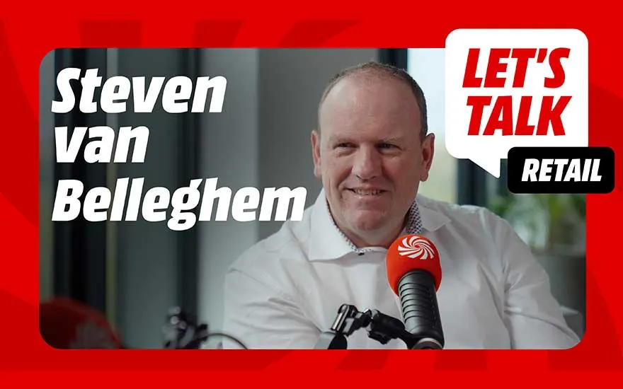 Een man in een studio zit lachend voor een microfoon, omringd door rode branding en kaders, met grote witte tekst over een retailpodcast.