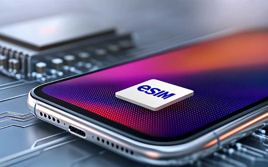 Moderne smartphone met kleurrijk scherm toont witte eSIM-chip op paars-roze achtergrond naast laptop op bureau.