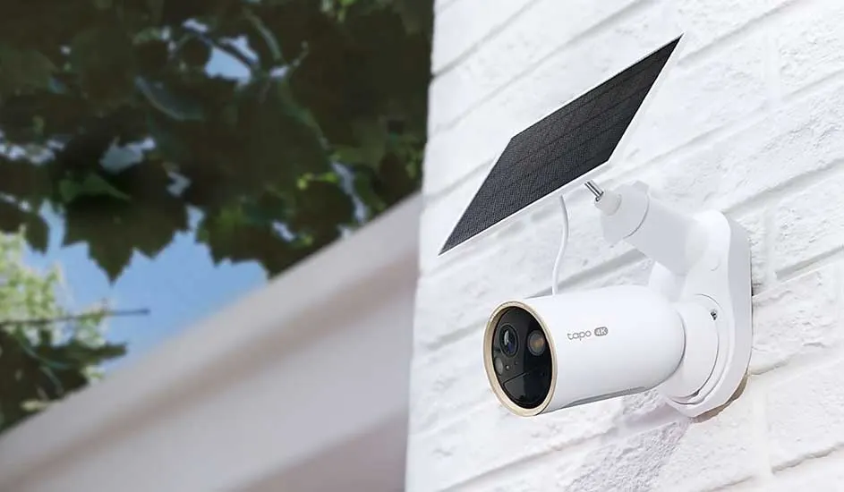 Een witte camera die buiten hangt.