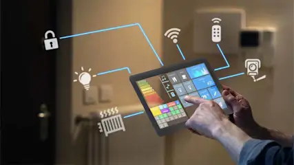 Een persoon gebruikt een tablet voor domotica, met pictogrammen voor beveiliging, verlichting en verwarming, verbonden door blauwe lijnen.