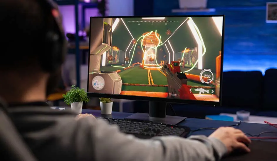Een gamer met koptelefoon zit aan een bureau en speelt een kleurrijke first-person shooter op een monitor, met plantjes naast het toetsenbord.