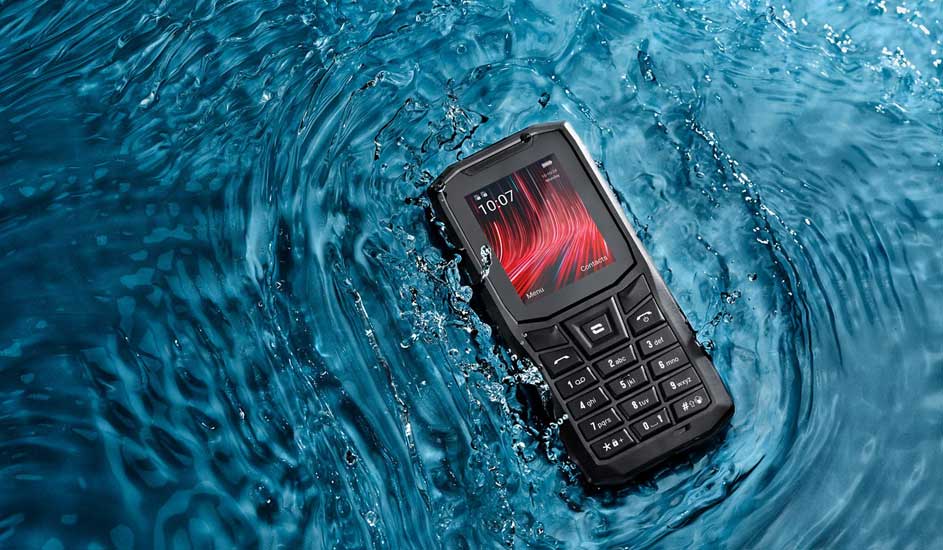 Een robuuste mobiele telefoon ligt in het water en blijft drijven. Het merk is niet zichtbaar op het toestel in de afbeelding.