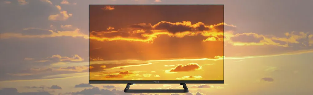 Een platte Finlux televisie toont een zonsondergang met wolken; het scherm en de merknaam Finlux zijn duidelijk zichtbaar.