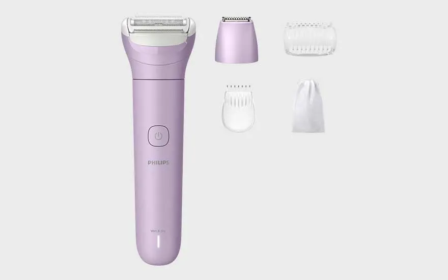 Een paarse Philips elektrische ladyshave met verschillende opzetstukken en een opbergzakje liggen op een witte achtergrond.