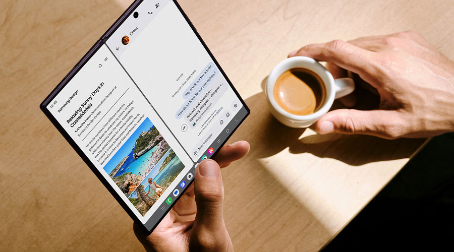 Persoon gebruikt een opengevouwen Galaxy Z Fold naast een kop koffie.