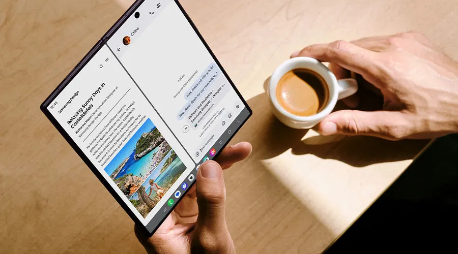 Persoon gebruikt een opengevouwen Galaxy Z Fold naast een kop koffie.