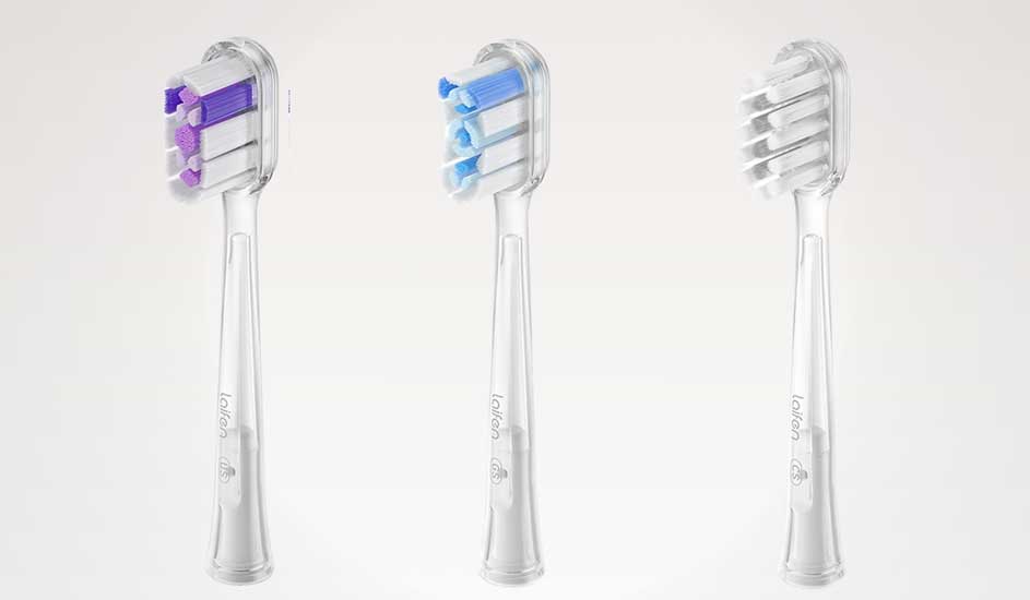 Drie opzetborstels voor elektrische tandenborstels van het merk Oclean staan naast elkaar, met paarse, blauwe en witte borstelharen.