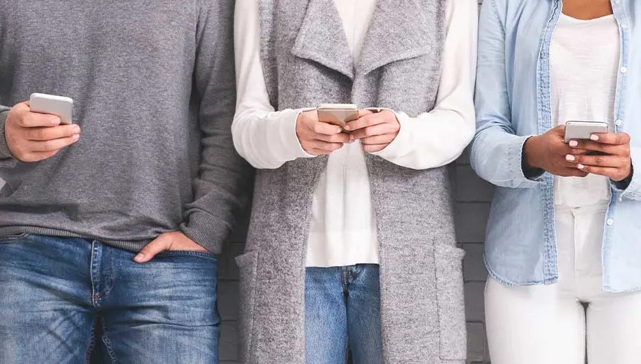 Een groep mensen zit in een cirkel, elk met een smartphone in de hand. Ze dragen kleding in blauwe, rode en beige tinten.