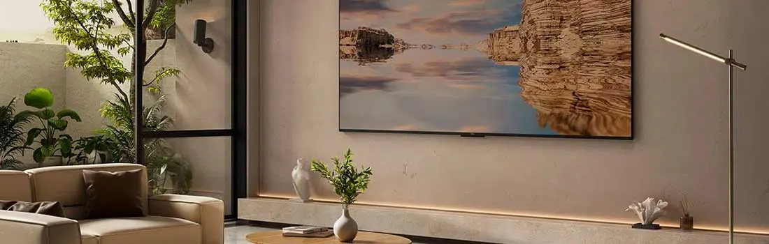 Een stijlvolle woonkamer toont een grote flatscreen-tv met een rustgevend landschap, omringd door planten en modern meubilair.
