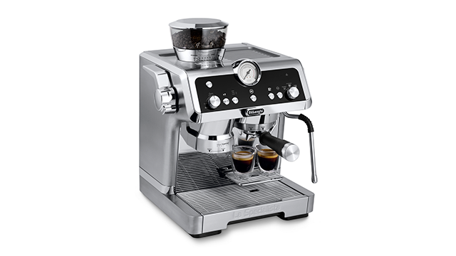 Een zilverkleurig DeLonghi-espressomachine met twee glazen espresso op een wit oppervlak.