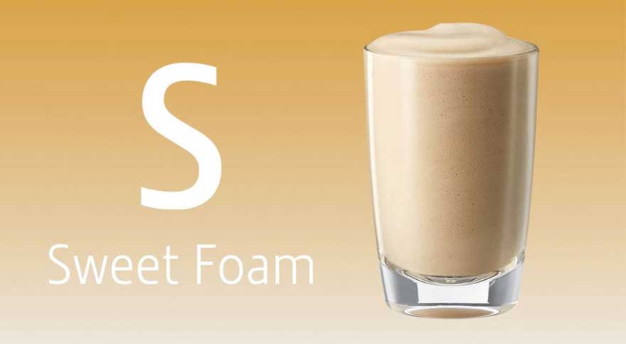 Gele achtergrond met een grote letter S en de tekst “Sweet Foam”; rechts een hoog glas gevuld met romig, licht schuim tot bovenaan.