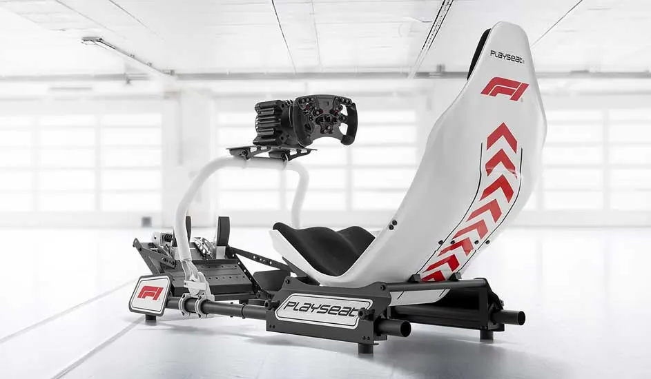 A sleek white F1 racing simulator seat with red graphics, mounted on a black frame with wheel and pedals, stands ready in a bright studio.