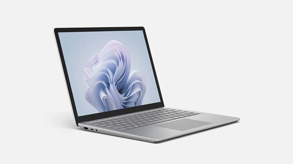 Een open, zilverkleurige laptop staat op een witte achtergrond. Het scherm toont een abstracte, bloemachtige afbeelding.