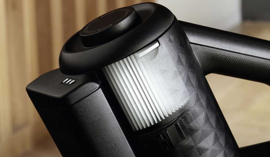 Close-up of a black Philips vacuum cleaner with a visible filter and textured pattern on the device.