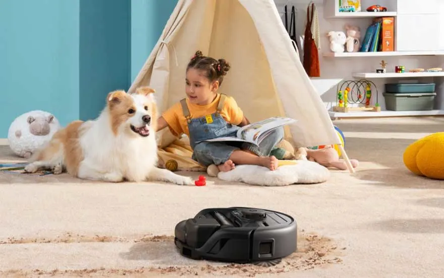 Een kind speelt met haar hond terwijl een robotstofzuiger het tapijt schoonmaakt, ideaal voor gezinnen met huisdieren.