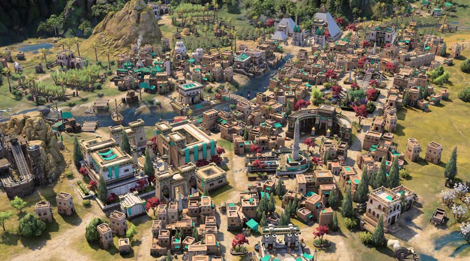 Een overzicht van een drukke stad met zandkleurige gebouwen, groene bomen en bergen op de achtergrond.