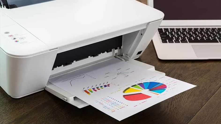 Een witte printer print een vel papier met een staafdiagram en een cirkeldiagram. Naast de printer staat een laptop.