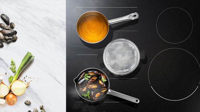 Een aanrecht met uien en mosselen naast een kookplaat met drie pannen gevuld met water en mosselen.