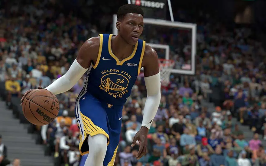 Een basketballer in een Warriors-uniform dribbelt de bal op een druk veld tijdens een intense wedstrijd.