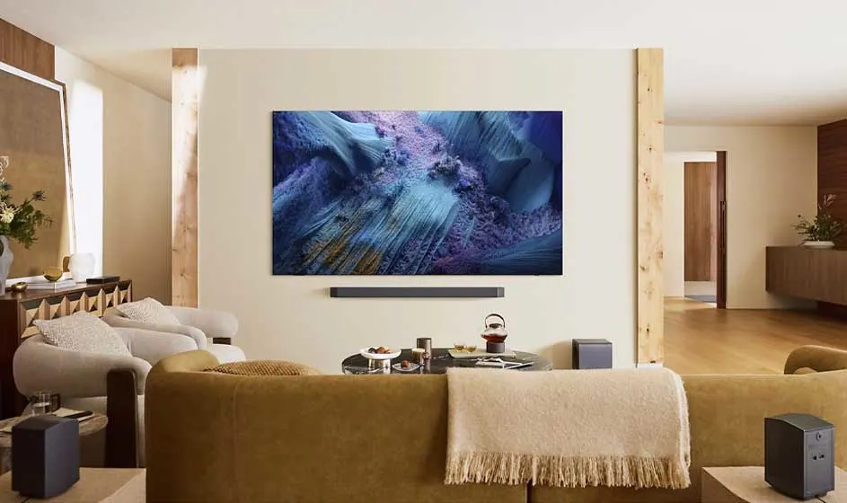 Een ruime woonkamer heeft een grote tv met abstract beeld, een soundbar en losse speakers; alles oogt warm en stijlvol.