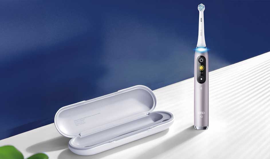 Slim electric toothbrush glowing blue beside an open white travel case on a bright surface, shown in a clean, modern minimalist style.