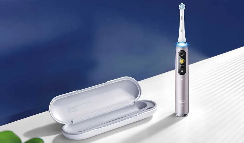 Slanke elektrische tandenborstel met blauw licht naast een open wit reisetui op een helder oppervlak, minimalistisch en modern gepresenteerd.