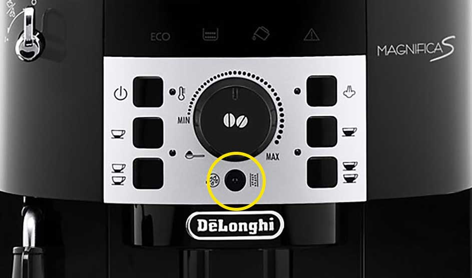 Op de foto zie je het bedieningspaneel van de DeLonghi Magnifica S koffiemachine met diverse knoppen en draaiknop in het midden.