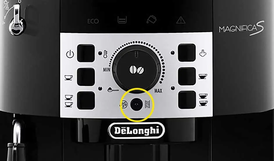 Op de foto zie je het bedieningspaneel van de DeLonghi Magnifica S koffiemachine met diverse knoppen en draaiknop in het midden.