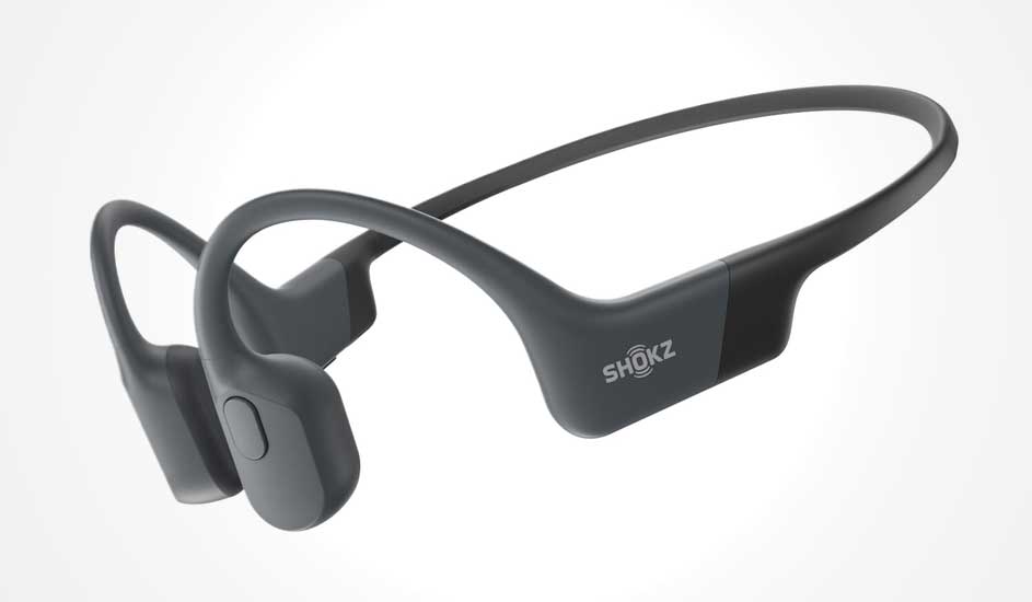 Dark grey Shokz bone conduction headphones with slim neckband and open-ear design, shown floating against a pale background.