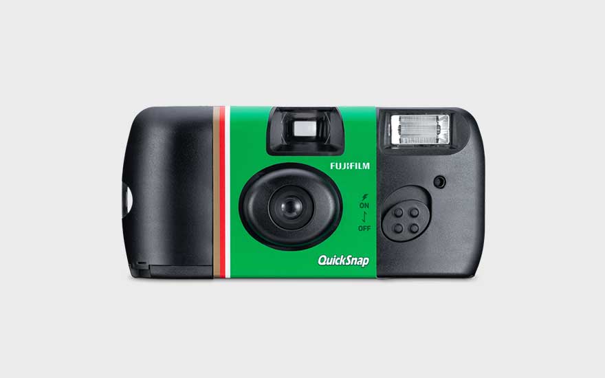 Een Fujifilm QuickSnap wegwerpcamera met groene striping staat centraal op een lichtgrijze achtergrond, lens en flitser zichtbaar.